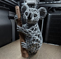 3D printed grey voronoi koala sculpture clinging to a branch