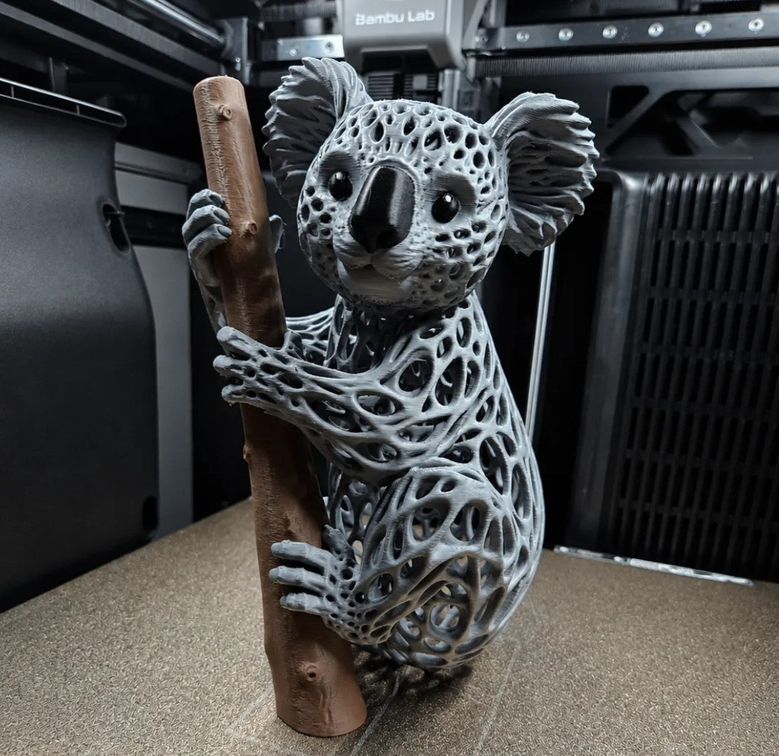 3D printed grey voronoi koala sculpture clinging to a branch