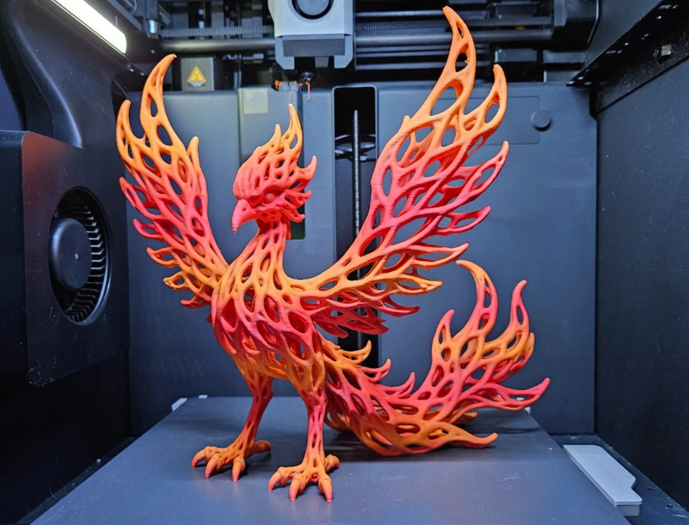 3D printed red-orange gradient phoenix sculpture with lattice wings