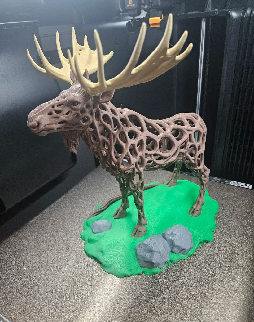 3D printed voronoi moose sculpture with green base and cream antlers